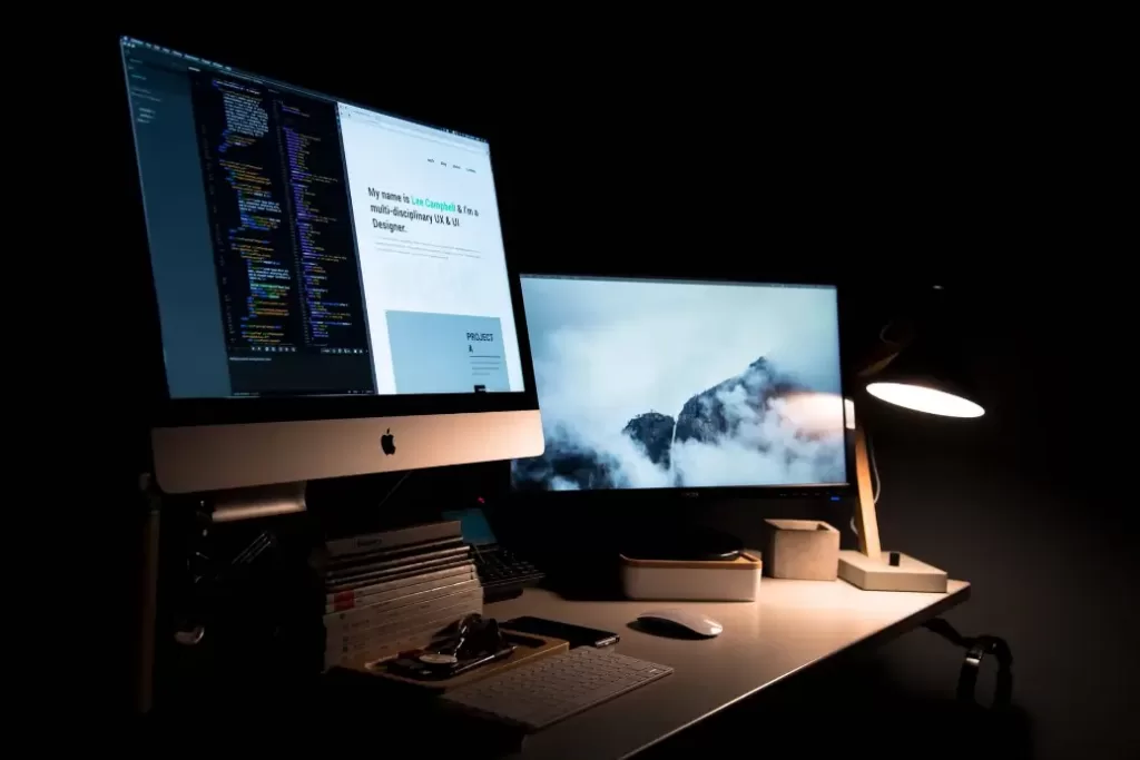 Desk with computer and light where person can make $13,000 a year.