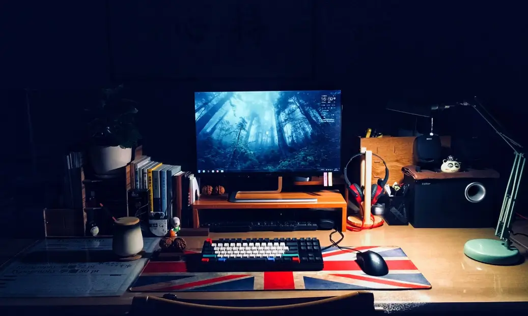 A workspace with a computer and headset where a person can make $23,000 a year.