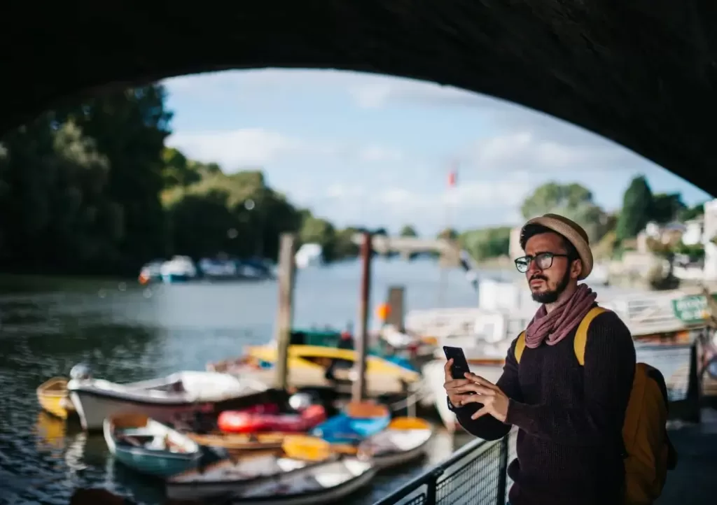 Man with glasses standing next to a river earning $45,000 a year.