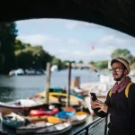 Man with glasses standing next to a river earning $45,000 a year.