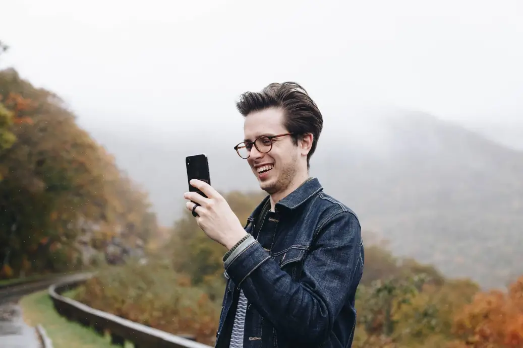 Man looking at his phone earning $51,000 a year.