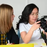 Two women working with a camera while earning $70,000 a year.