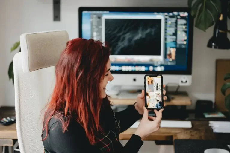 Woman with red hair and phone earning $72,000 a year.